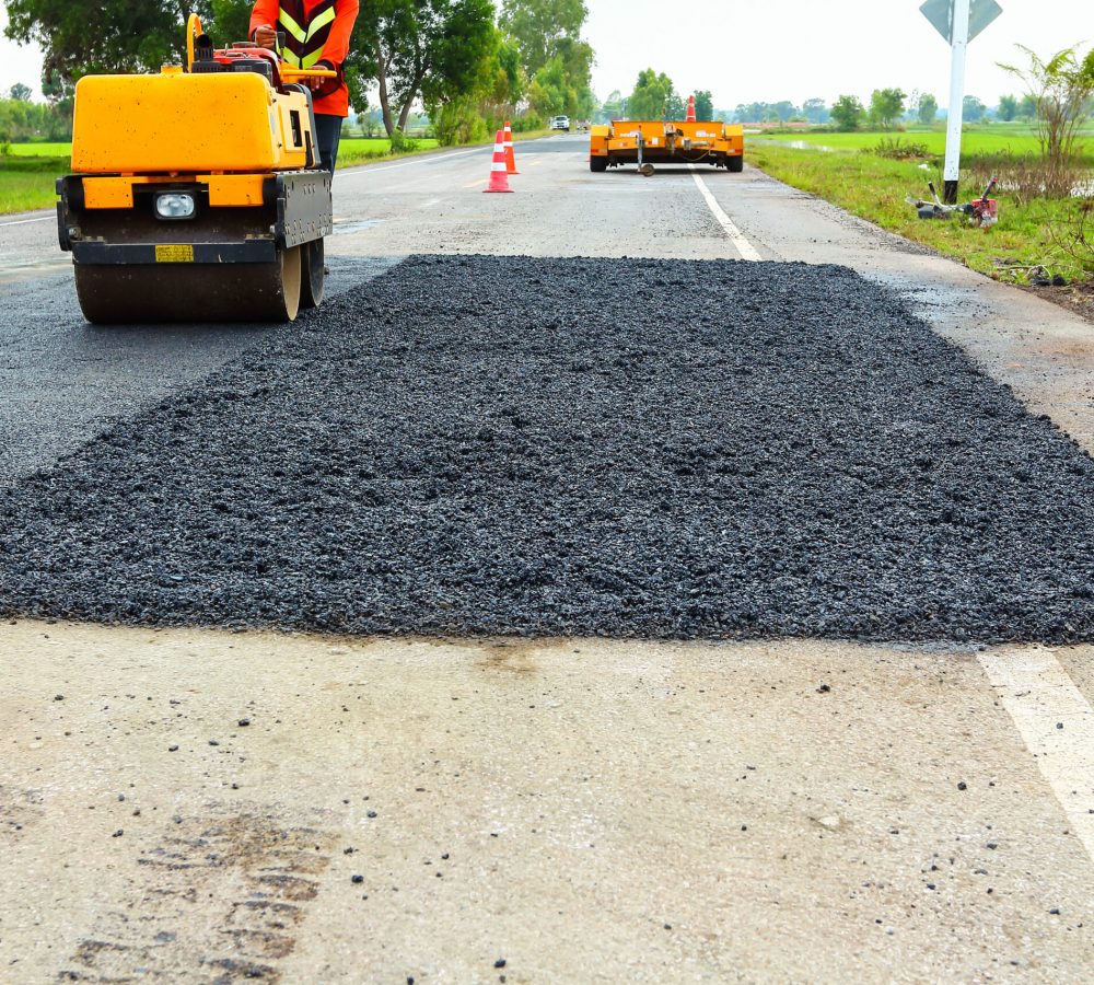 Road repair. Construction Worker Asphalting. Pothole repair